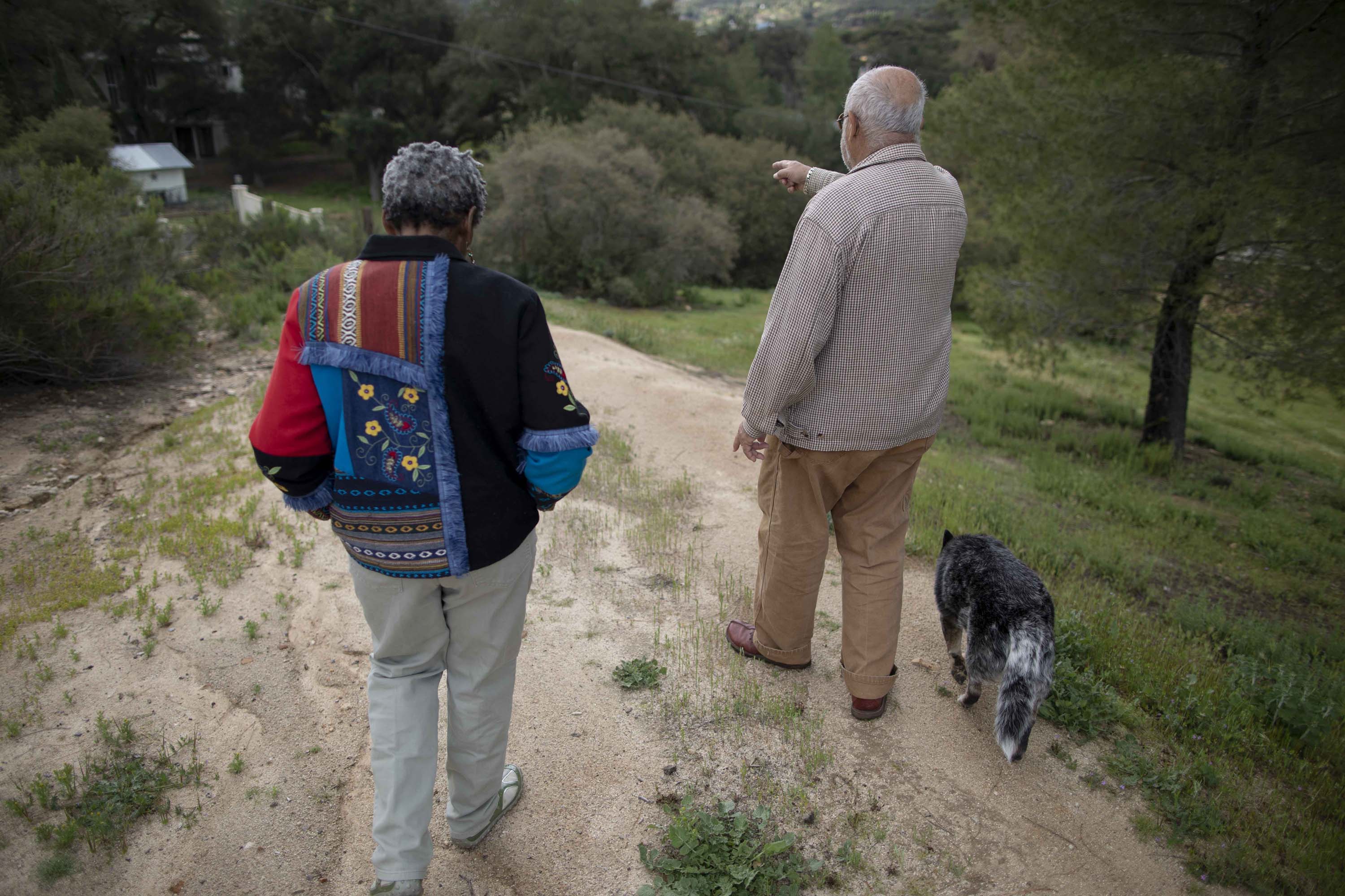 Carlos Luis Ituarte and his wife, Gerda Govine Ituarte, walk with their dog, Tres Colores, on their 4 &frac12; acre property in rural Jamul.