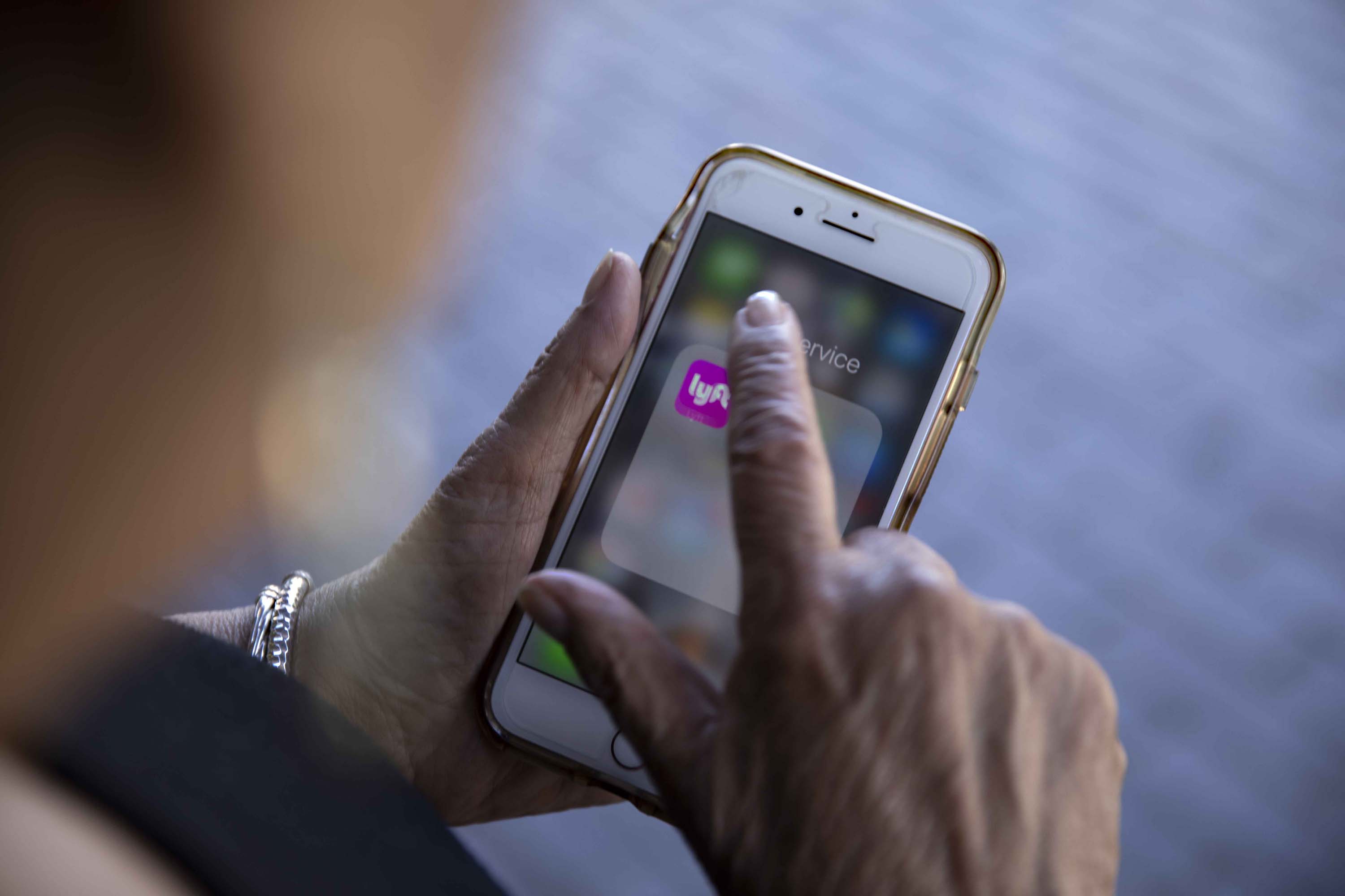 Regina Jones requests a Lyft from her phone after an opthamologist's appointment in Beverly Hills. Jones says the ride-share app is &ldquo;freedom.&rdquo;